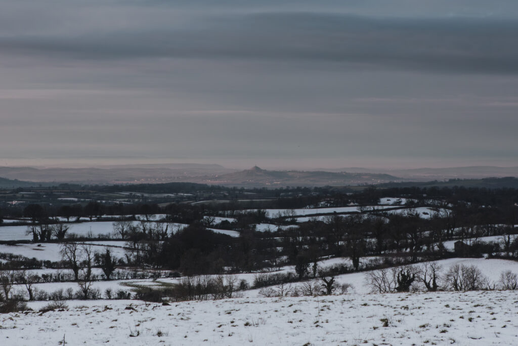 Example of a larger number f/stop used for landscapes - A picture of Glastonbury Tor from a snowy field at Beacon Hill Woods.