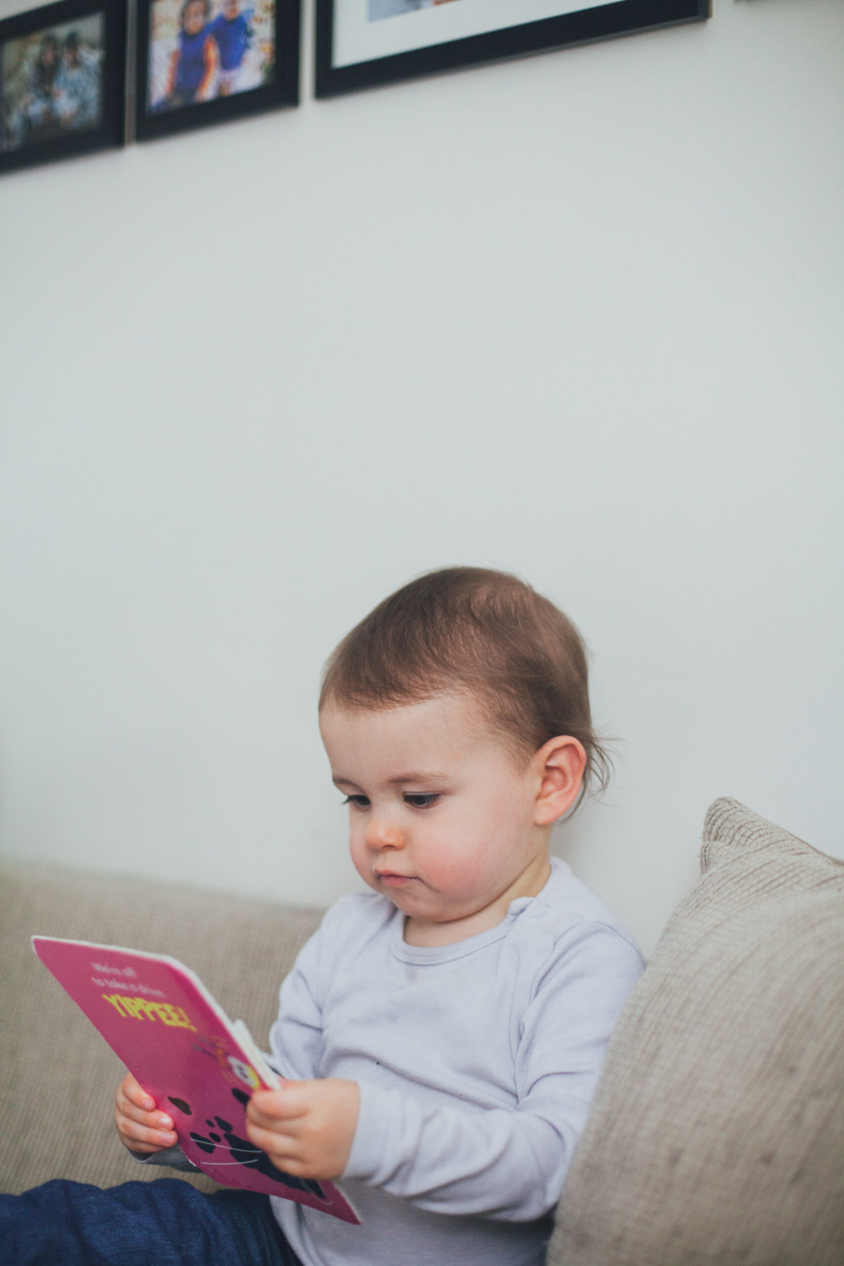 Child Photography Ideas At Home - Toddler reading a book on the sofa