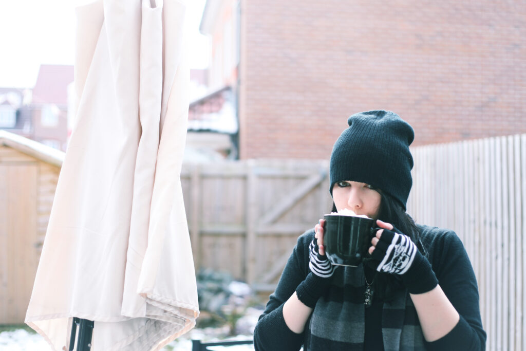 Portrait of a woman outside in the snow sipping a hot chocolate