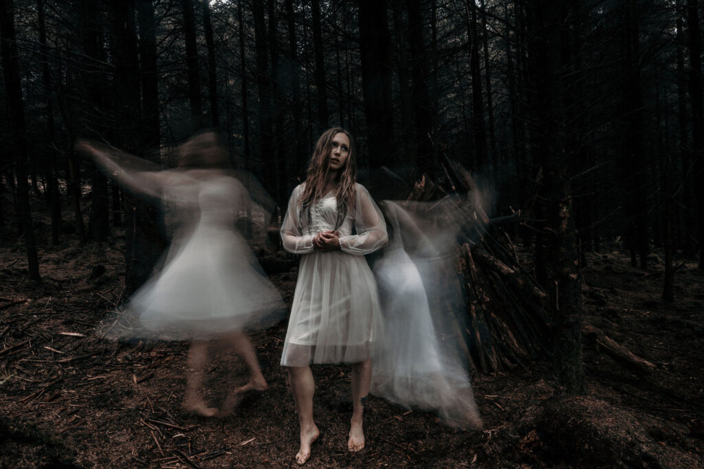 Example of emotion in photography: Picture of woman standing in a forest surrounded by ghosts