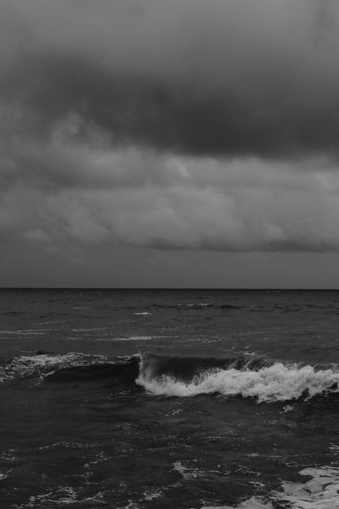 Black and white picture of the ocean on a cloudy stormy day