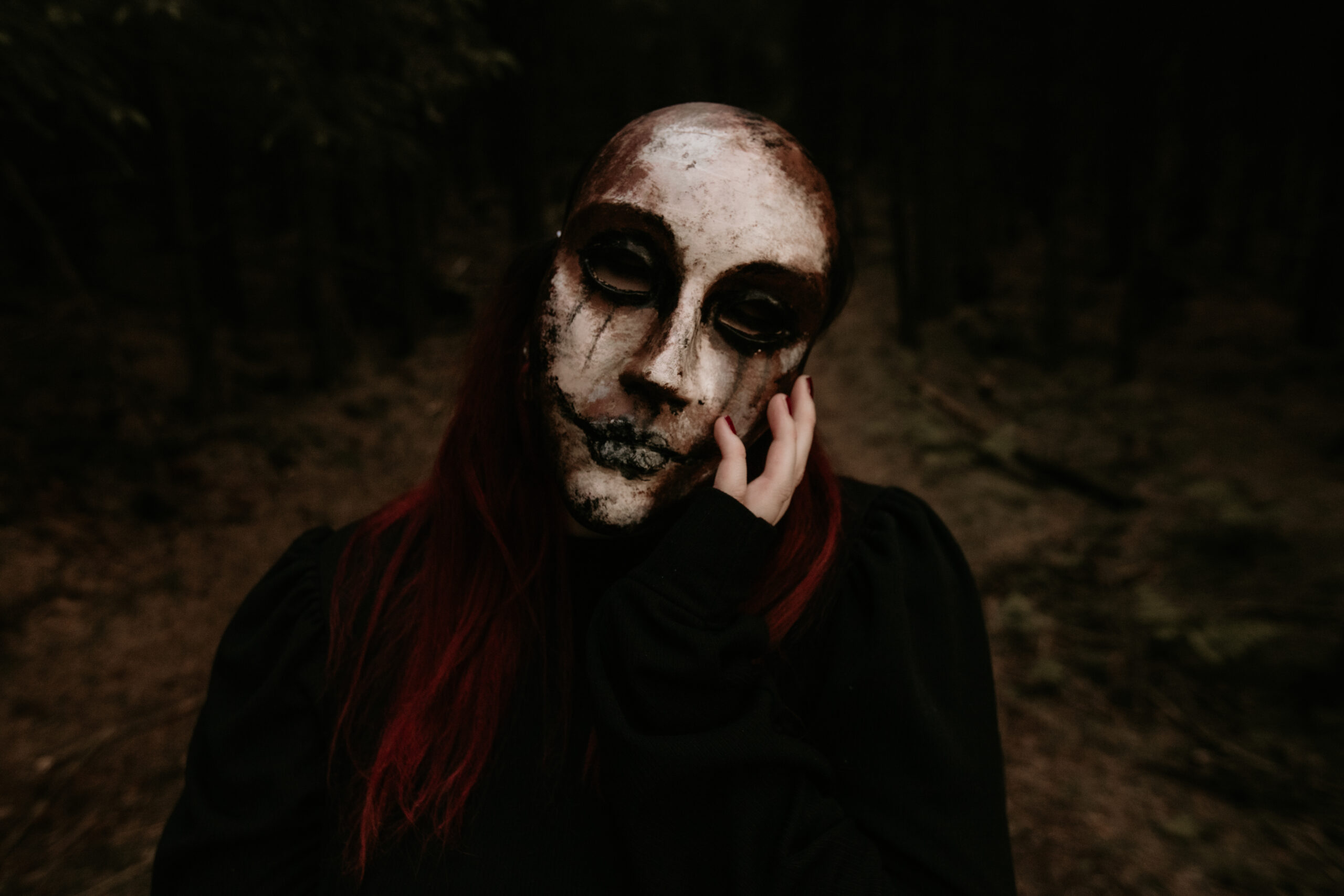 Woman with a mask that has tears running from eyes