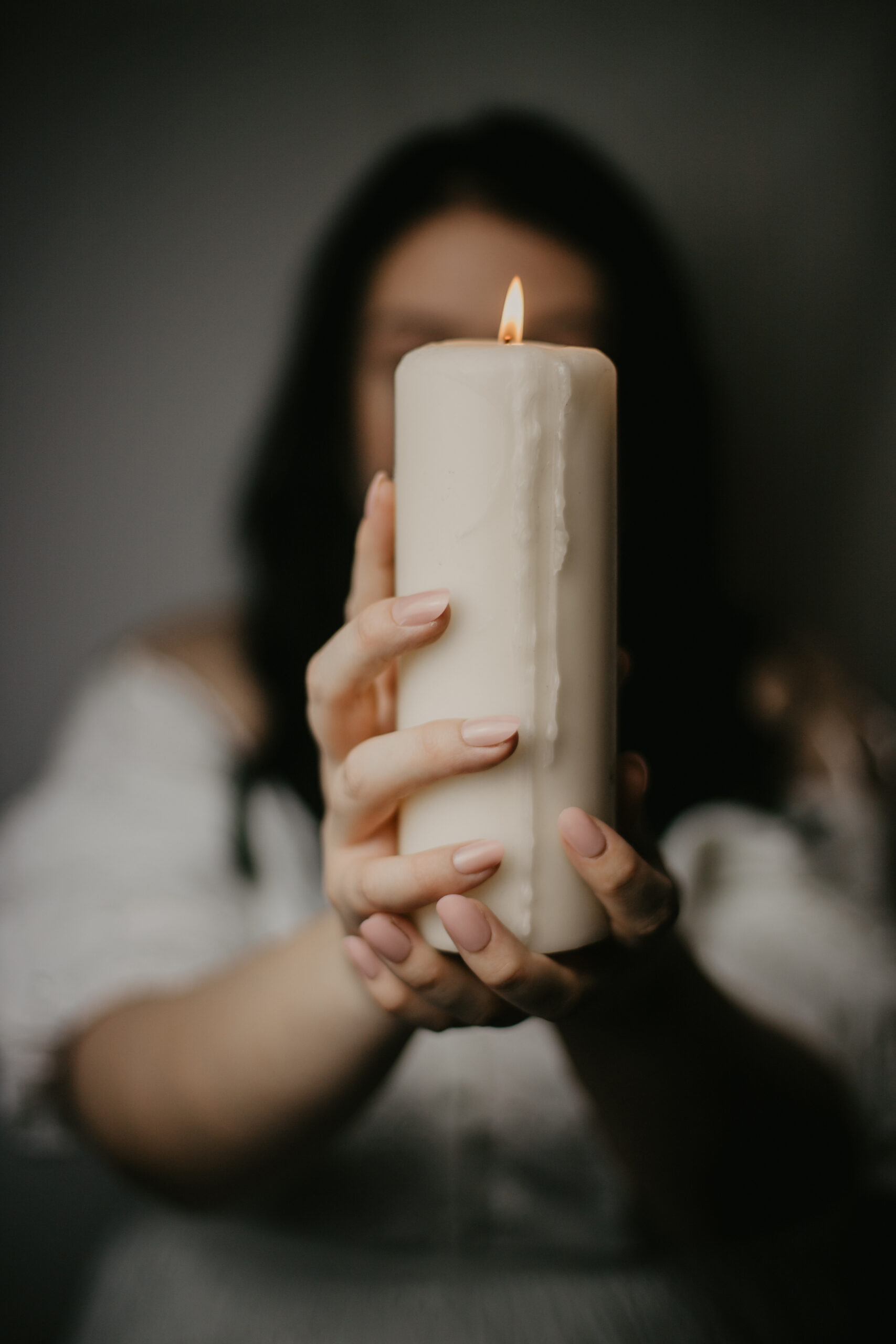 Faceless self portrait of woman holding candle